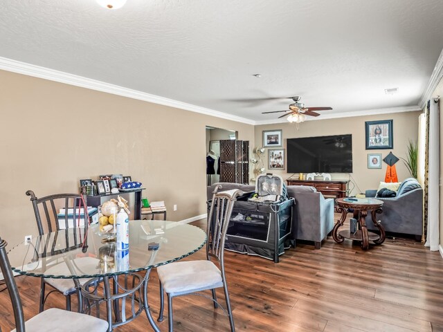 dining room with ceiling fan, a textured ceiling, crown molding, and wood-type flooring