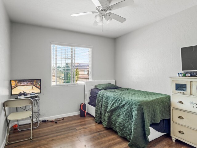 bedroom with dark hardwood / wood-style floors and ceiling fan