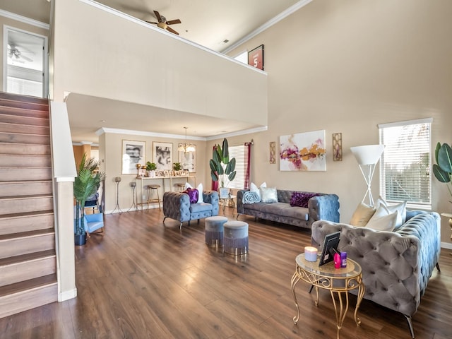 living room with crown molding, ceiling fan, and dark wood-type flooring