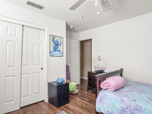 bedroom featuring dark wood-type flooring, ceiling fan, and a closet