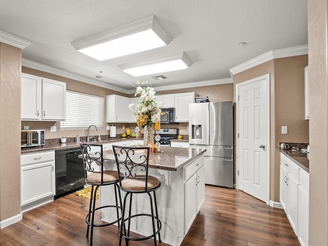 kitchen with white cabinets, dishwasher, a kitchen island, and stainless steel fridge