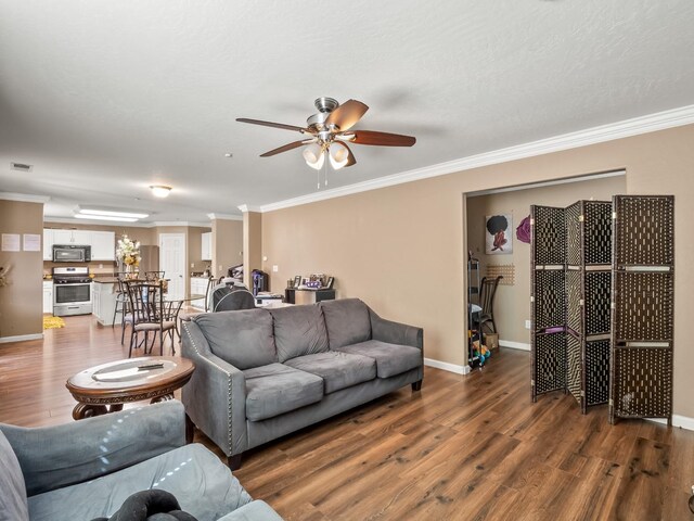 living room featuring crown molding, ceiling fan, and dark wood-type flooring