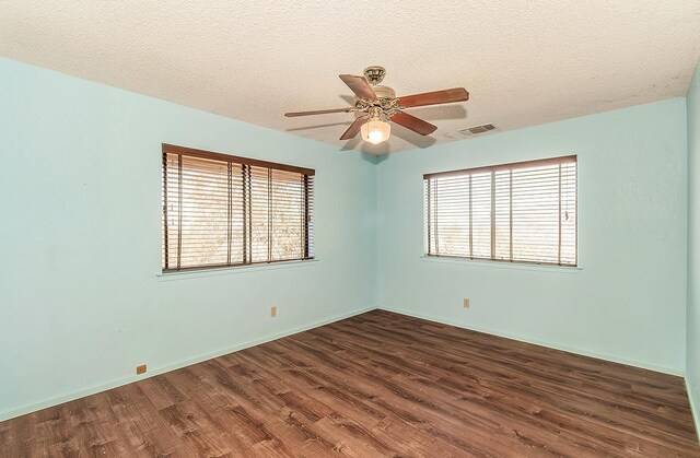 empty room featuring ceiling fan, a textured ceiling, and dark hardwood / wood-style flooring