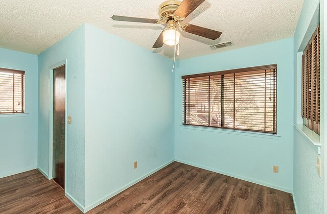 unfurnished room with a textured ceiling, dark hardwood / wood-style flooring, and ceiling fan