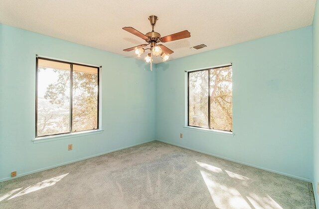 unfurnished room featuring a textured ceiling, ceiling fan, and light colored carpet