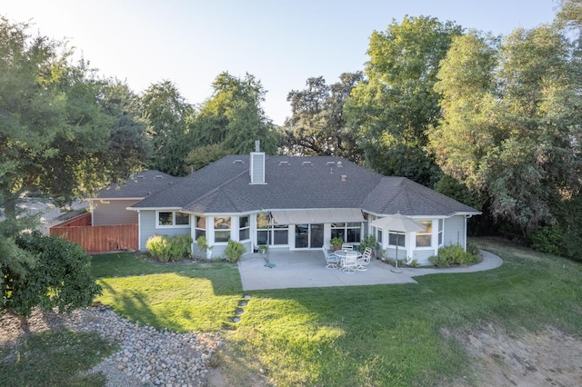 rear view of property featuring a lawn and a patio area