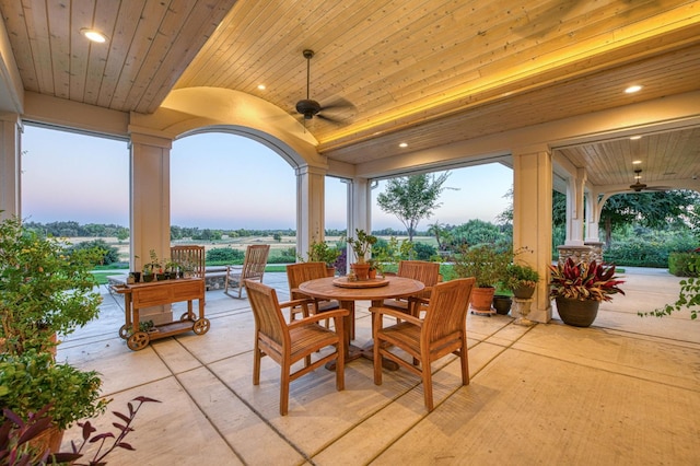 patio terrace at dusk featuring ceiling fan