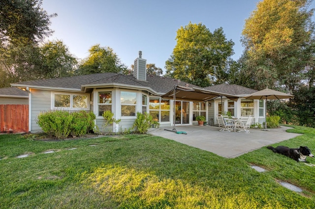 rear view of house with a yard and a patio