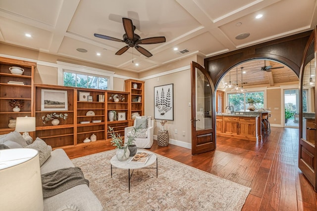 living room featuring ceiling fan, dark hardwood / wood-style floors, and beam ceiling