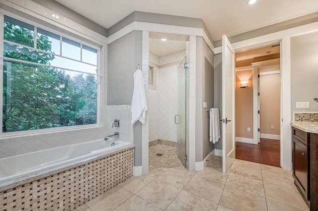 bathroom featuring tile patterned floors, independent shower and bath, and vanity