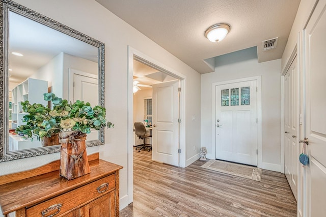 foyer with a textured ceiling, light hardwood / wood-style floors, and ceiling fan