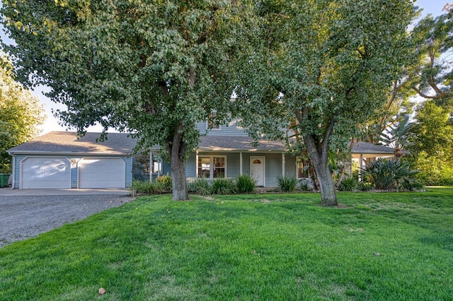 view of property hidden behind natural elements with a garage and a front lawn