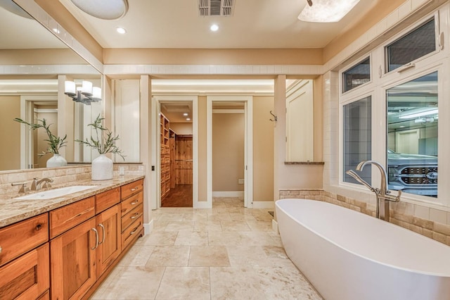 bathroom with a tub to relax in and vanity