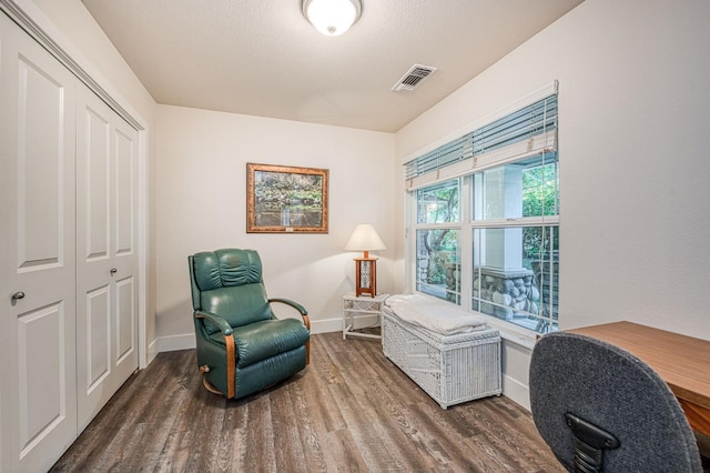 living area featuring a textured ceiling and dark hardwood / wood-style flooring