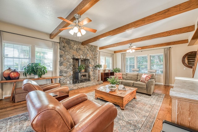 living room featuring ceiling fan, a fireplace, and a healthy amount of sunlight