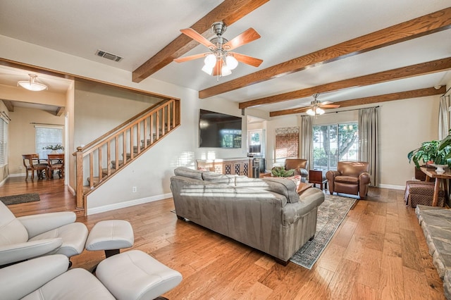 living room with beam ceiling, ceiling fan, and light hardwood / wood-style flooring