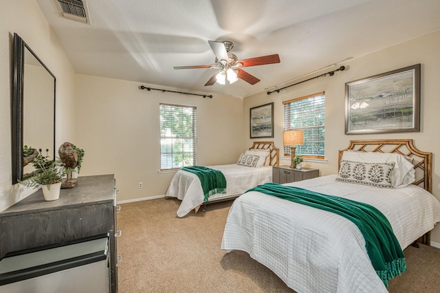 carpeted bedroom featuring ceiling fan and multiple windows