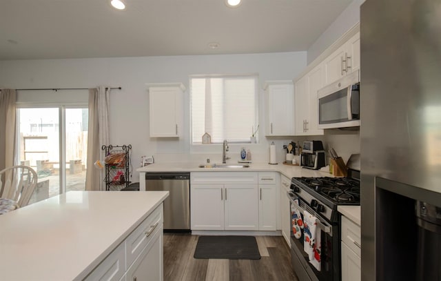 kitchen featuring white cabinets, appliances with stainless steel finishes, dark hardwood / wood-style flooring, and sink