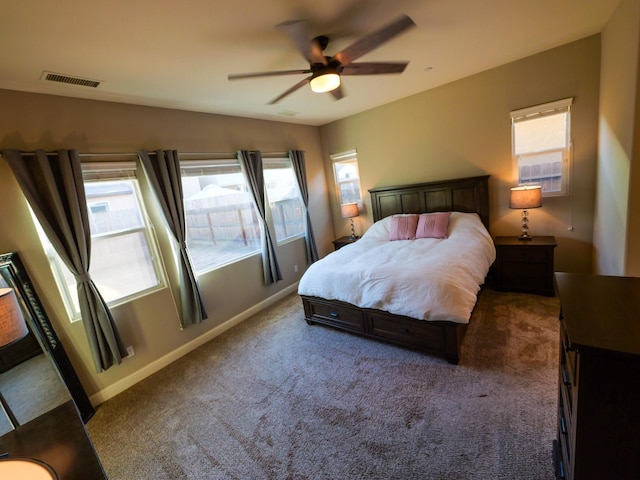 carpeted bedroom with multiple windows and ceiling fan