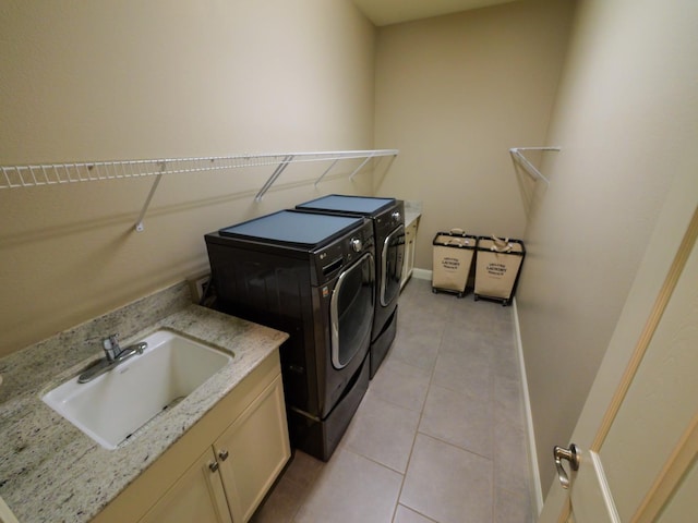 laundry room with sink, washing machine and dryer, cabinets, and light tile patterned flooring