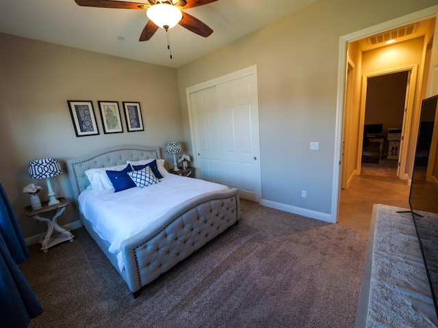 bedroom featuring dark carpet, ceiling fan, and a closet