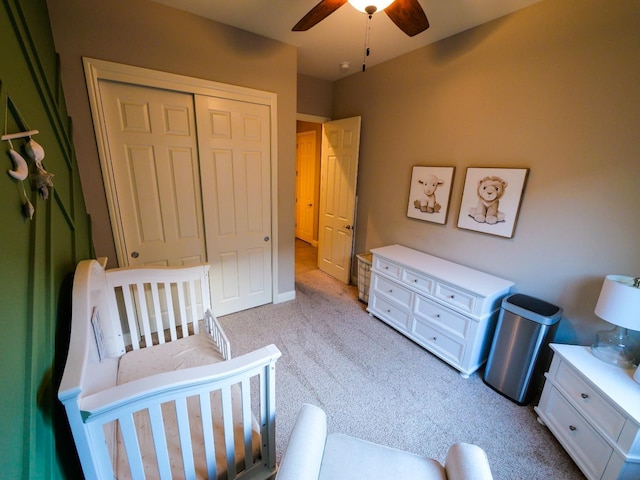 carpeted bedroom with ceiling fan and a closet