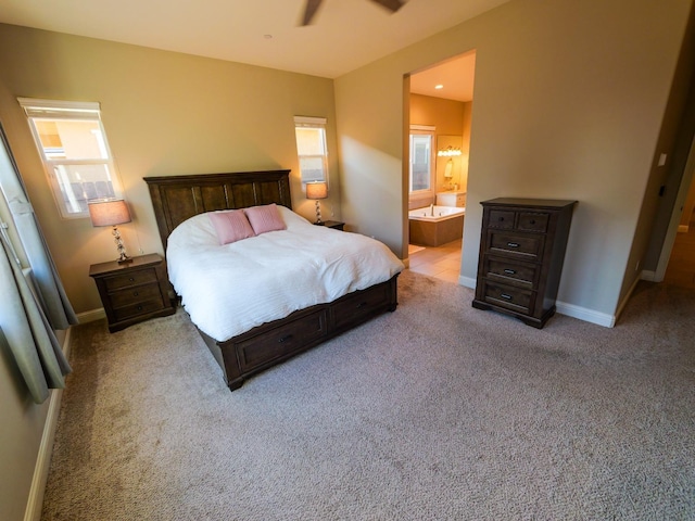 bedroom featuring multiple windows, light carpet, connected bathroom, and ceiling fan