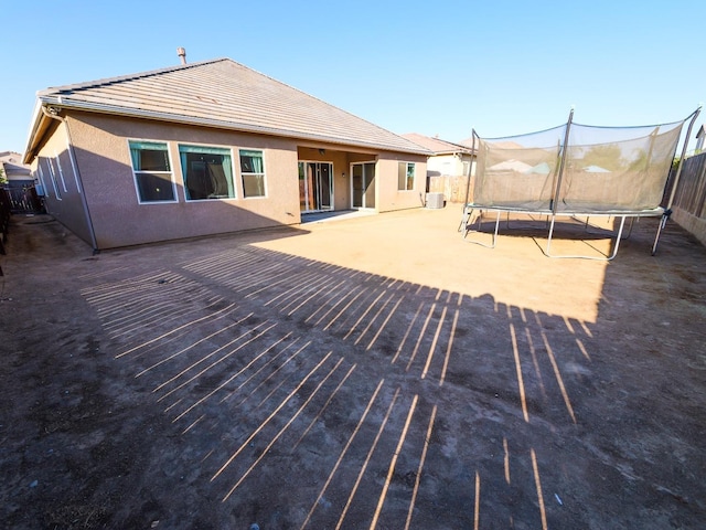 rear view of property featuring a trampoline