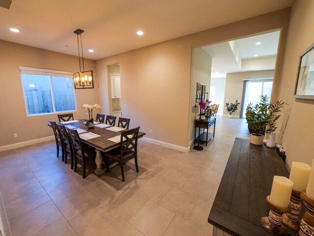 tiled dining room featuring an inviting chandelier