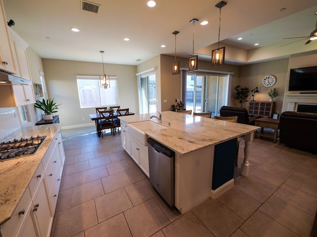 kitchen with white cabinetry, dishwasher, a center island with sink, and pendant lighting