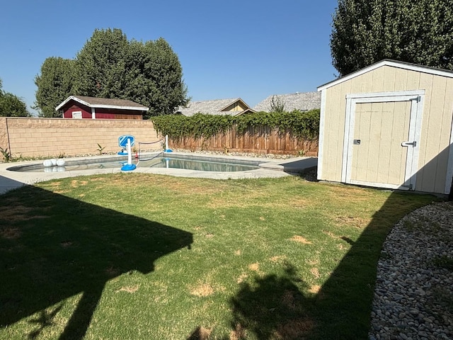 view of yard with a fenced in pool and a storage unit