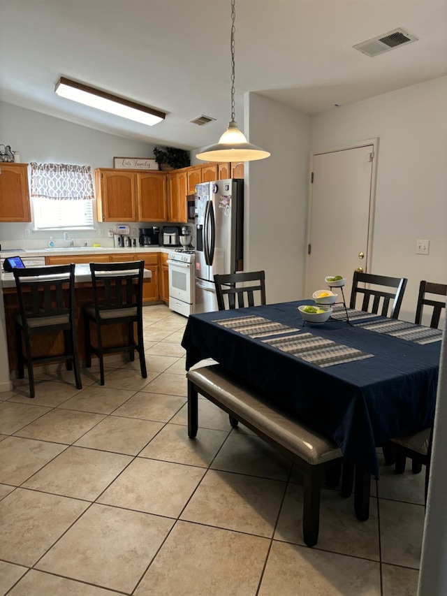 tiled dining room featuring lofted ceiling