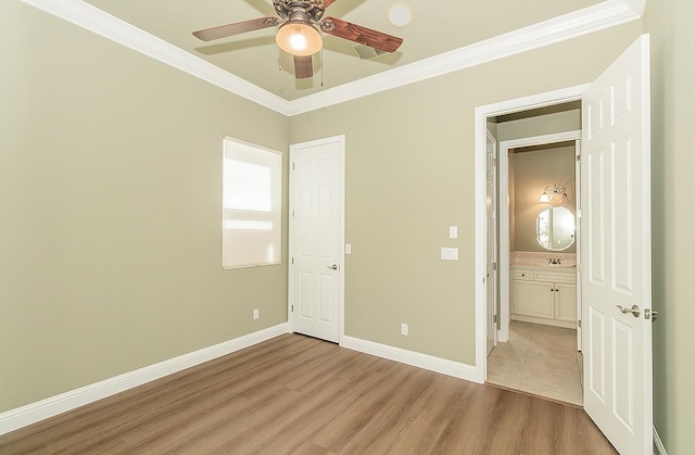 unfurnished bedroom with ornamental molding, light wood-type flooring, baseboards, and a ceiling fan