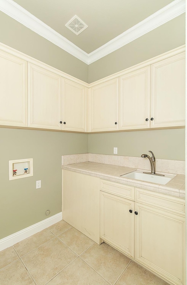 laundry room with light tile patterned floors, hookup for a washing machine, cabinet space, visible vents, and a sink