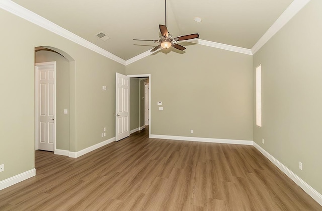 unfurnished room with arched walkways, light wood finished floors, visible vents, and baseboards