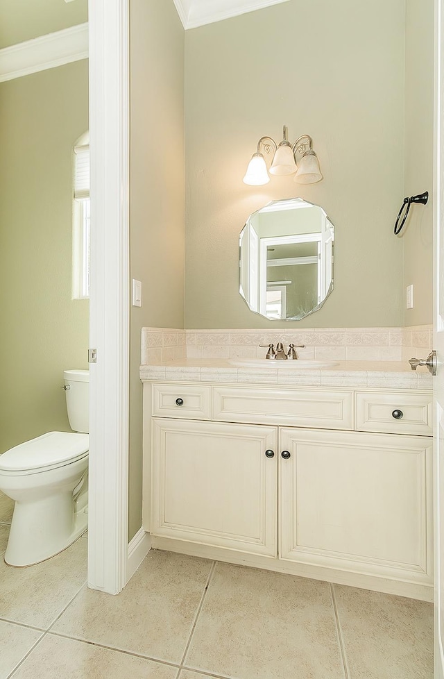 bathroom featuring toilet, tile patterned flooring, ornamental molding, and vanity