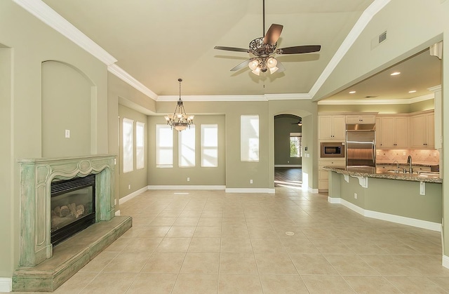 living room with arched walkways, ornamental molding, light tile patterned floors, and a glass covered fireplace