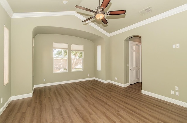 empty room with lofted ceiling, visible vents, baseboards, and wood finished floors