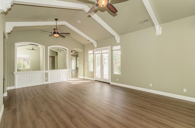 unfurnished living room featuring arched walkways, lofted ceiling with beams, wood finished floors, visible vents, and a ceiling fan