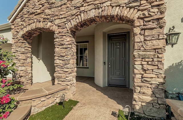 property entrance with stone siding and stucco siding