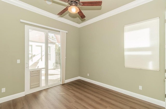 spare room with ornamental molding, baseboards, and wood finished floors