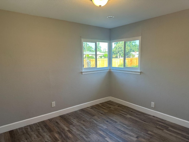 spare room with dark hardwood / wood-style flooring