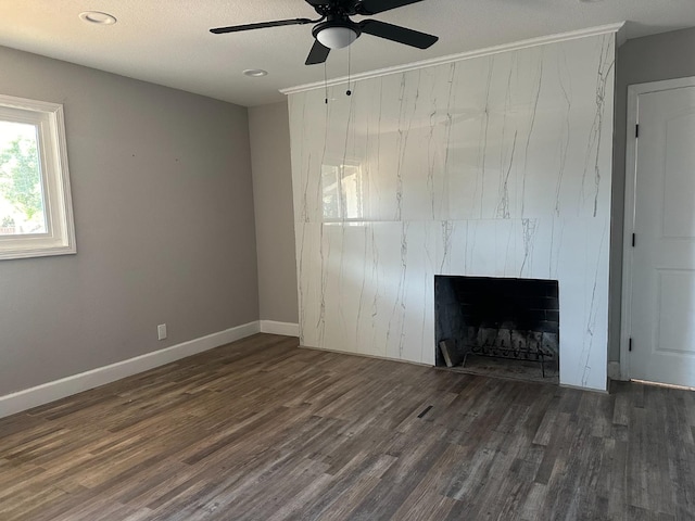 unfurnished living room featuring a textured ceiling, dark hardwood / wood-style flooring, and ceiling fan