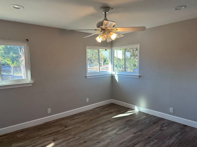 unfurnished room featuring dark hardwood / wood-style flooring, ceiling fan, and plenty of natural light