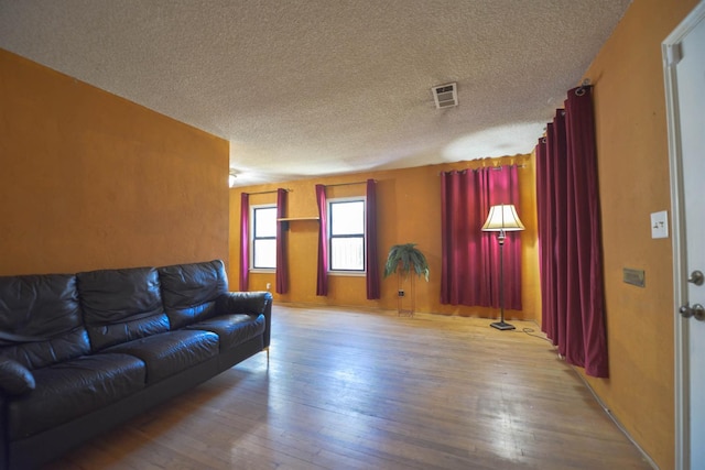 living room featuring a textured ceiling and light wood-type flooring