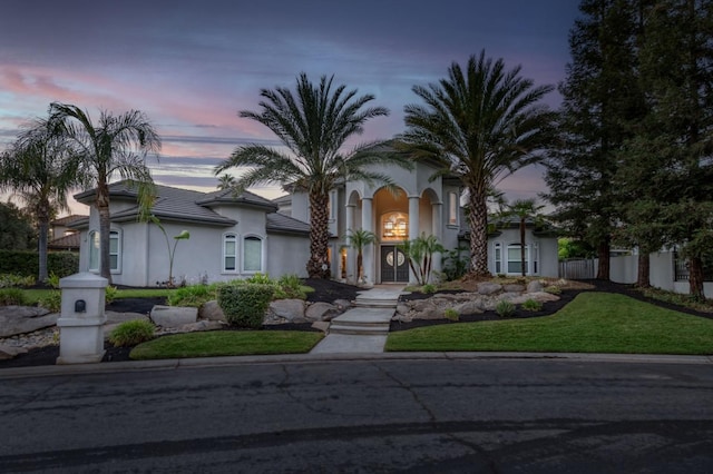 mediterranean / spanish house with a yard