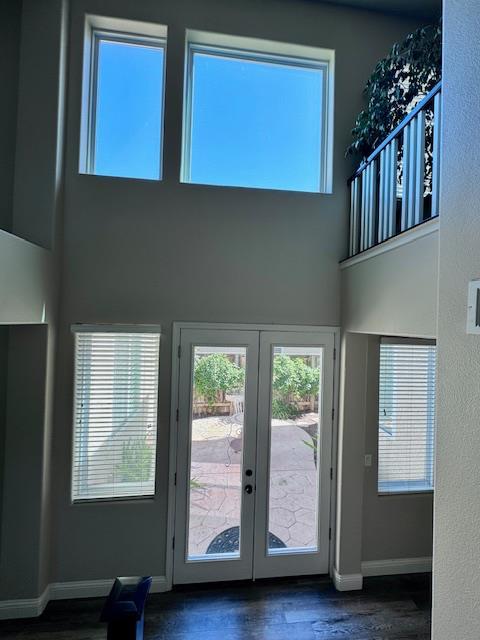 4707 N Arrow Ridge Way N, Clovis, CA 93619 - doorway with french doors, a towering ceiling, dark wood-style flooring, and baseboards