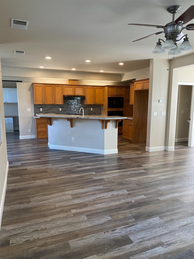 4707 N Arrow Ridge Way N, Clovis, CA 93619 - kitchen featuring ceiling fan, brown cabinets, dark wood finished floors, backsplash, and recessed lighting