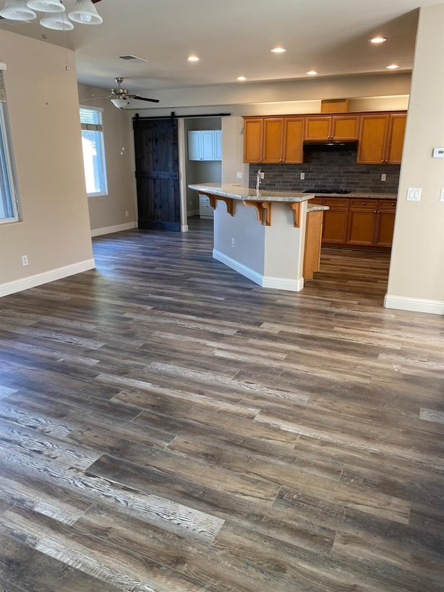 4707 N Arrow Ridge Way N, Clovis, CA 93619 - kitchen with a barn door, brown cabinets, open floor plan, dark wood finished floors, and recessed lighting
