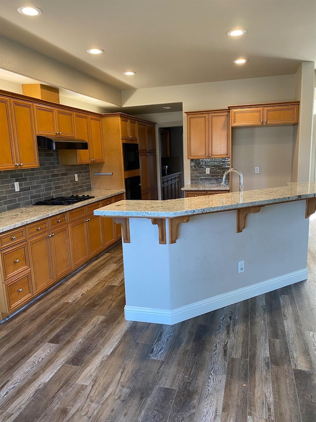 4707 N Arrow Ridge Way N, Clovis, CA 93619 - kitchen featuring brown cabinets, tasteful backsplash, dark wood finished floors, black gas cooktop, and recessed lighting